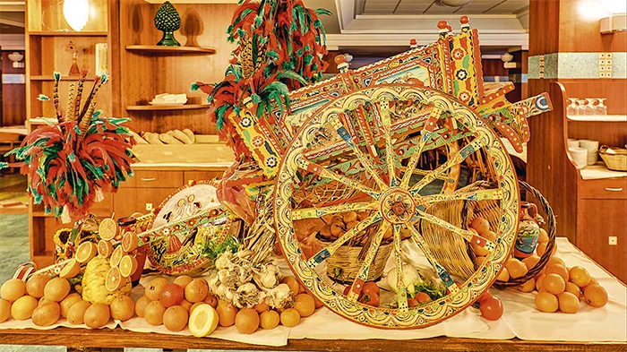 Decorazione tipica siciliana con carretto colorato e agrumi al buffet