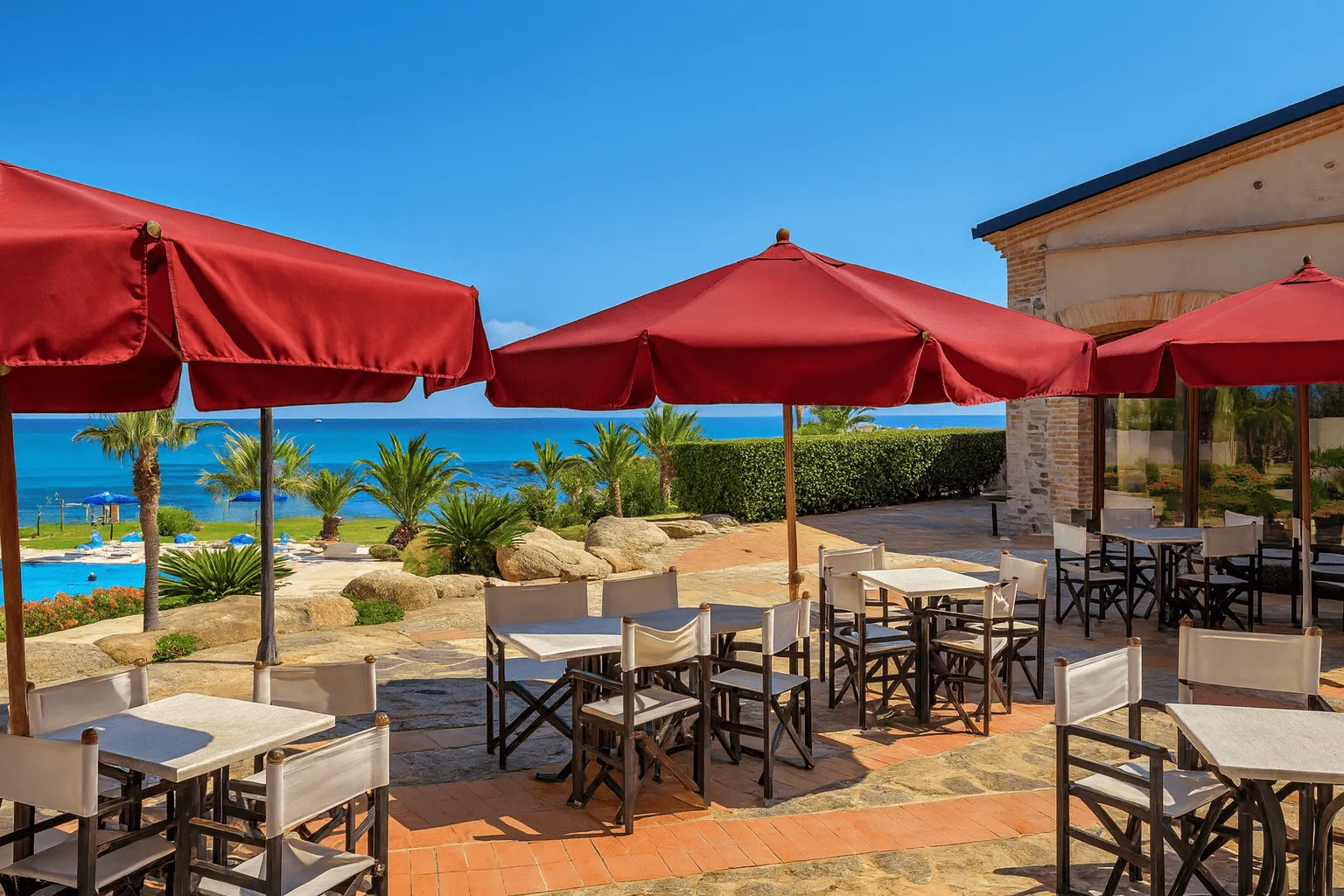 Terrazza ristorante con ombrelloni rossi e tavoli vista mare