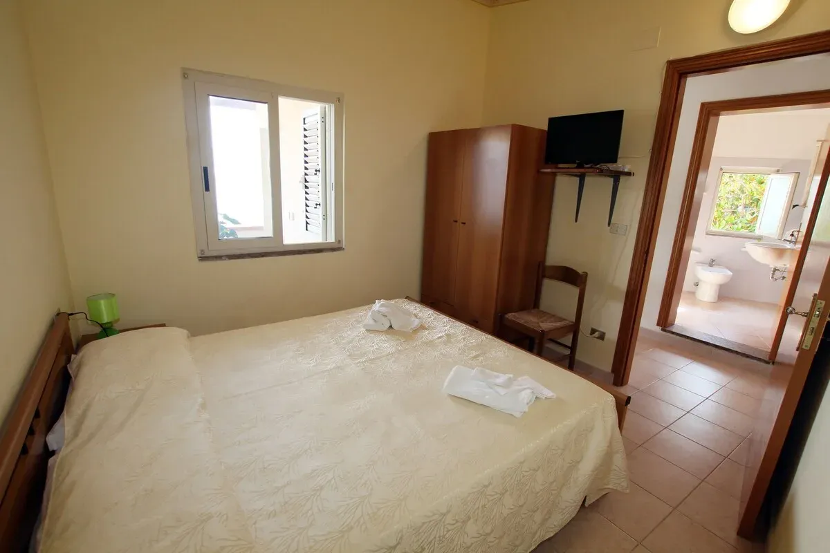 Camera matrimoniale con armadio, TV e bagno privato adiacente