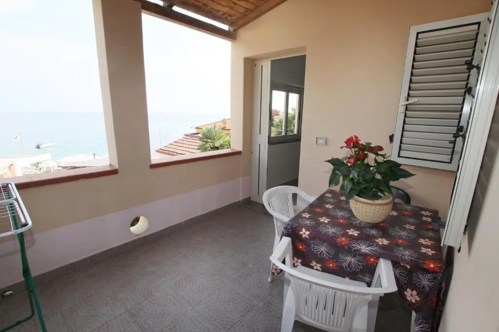 Balcone con tavolo, sedie e vista sul mare e sulla spiaggia