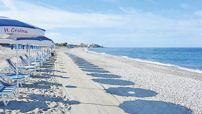 Lunga spiaggia con ombrelloni Hotel Cristina e mare calmo che si estende verso l'orizzonte