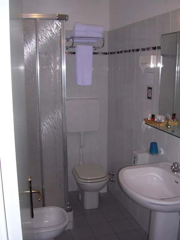 Bagno con doccia, bidet, WC e lavabo piastrellato in grigio chiaro