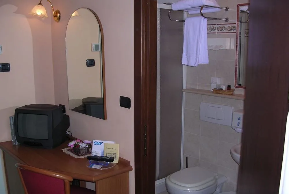 Angolo camera con TV, specchio e accesso al bagno con doccia