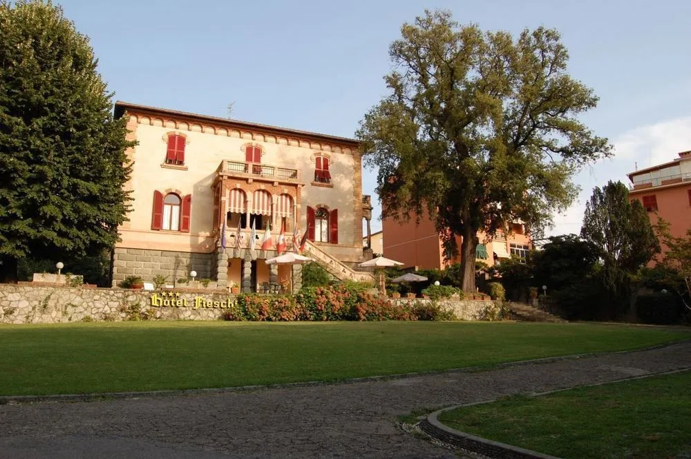 Villa storica al tramonto con giardino, prato verde e insegna Hotel Fieschi