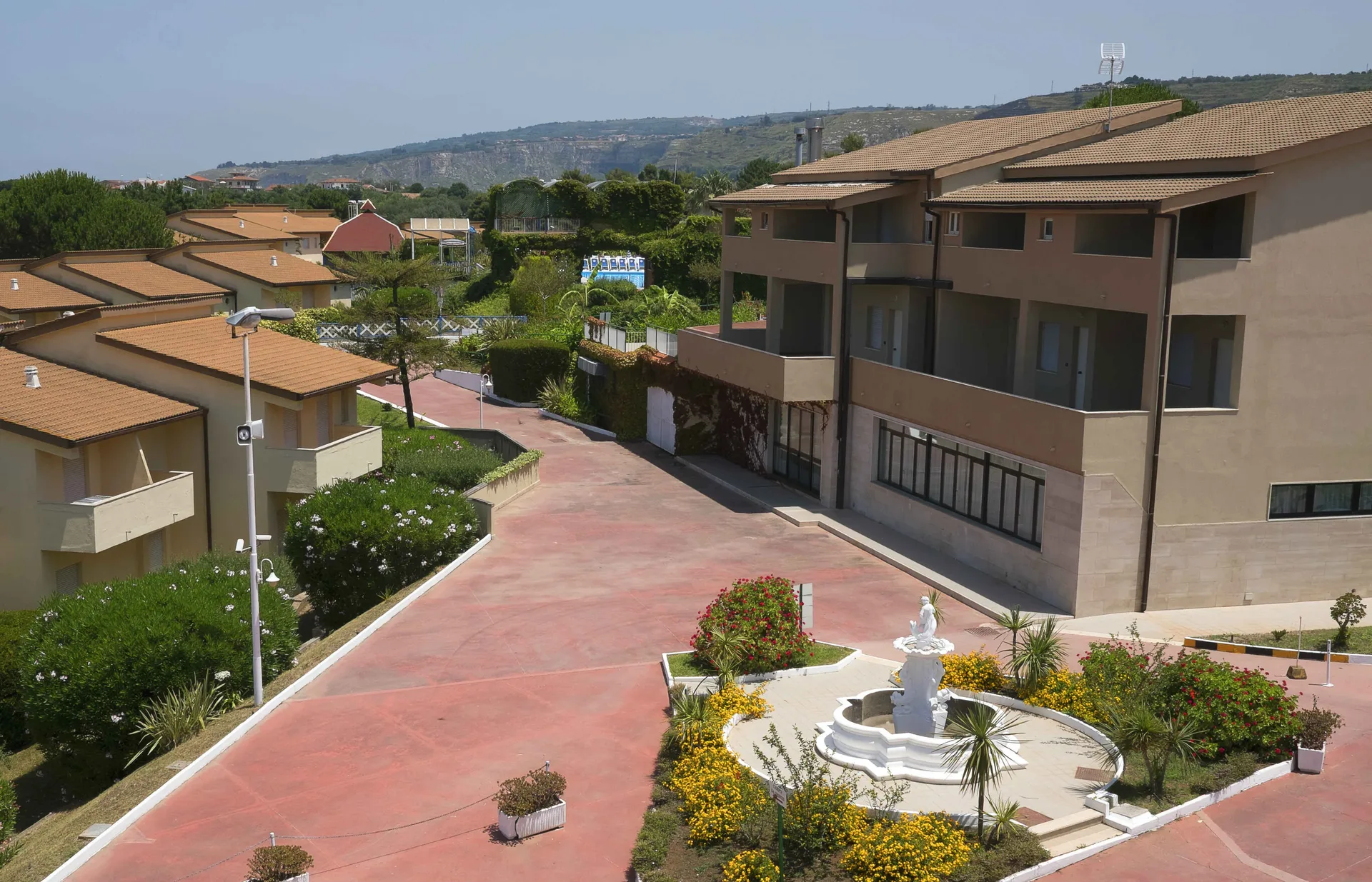 Veduta dall'alto degli edifici del resort con viali, fontana e giardini