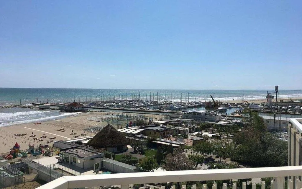 Panorama dal balcone su spiaggia, porto turistico e mare