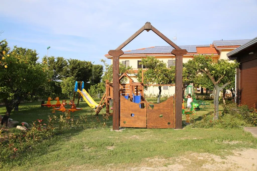 Area giochi per bambini con scivolo e altalene immersa nel verde