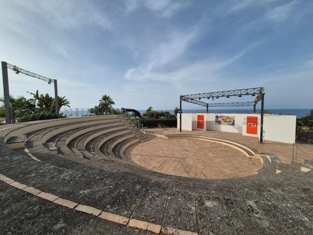 Anfiteatro all'aperto del resort con gradinate in pietra e palco vista mare