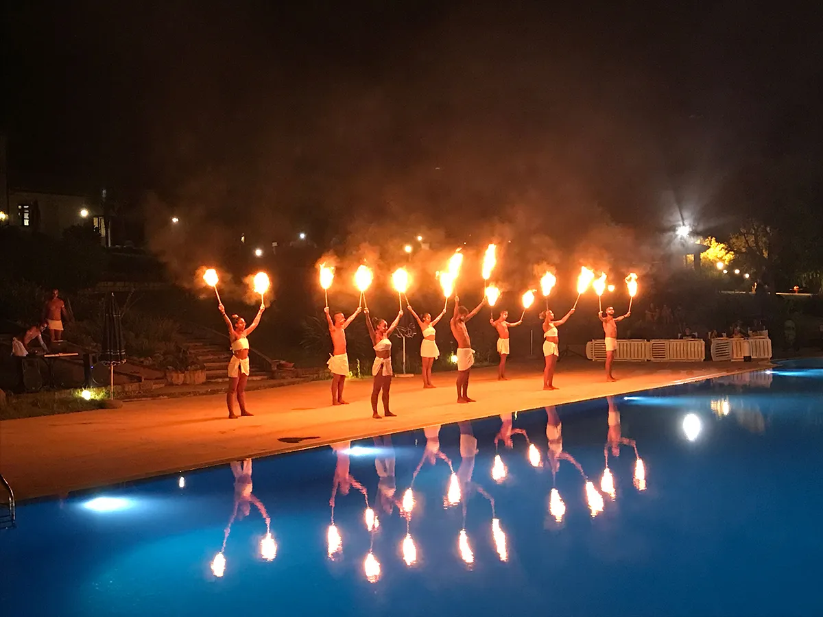 Spettacolo serale con artisti del fuoco a bordo piscina illuminata