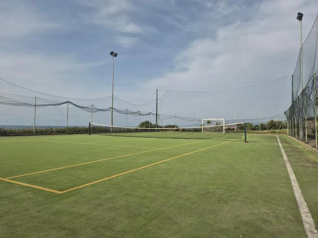 Campo sportivo polivalente in erba sintetica con reti di recinzione e vista mare