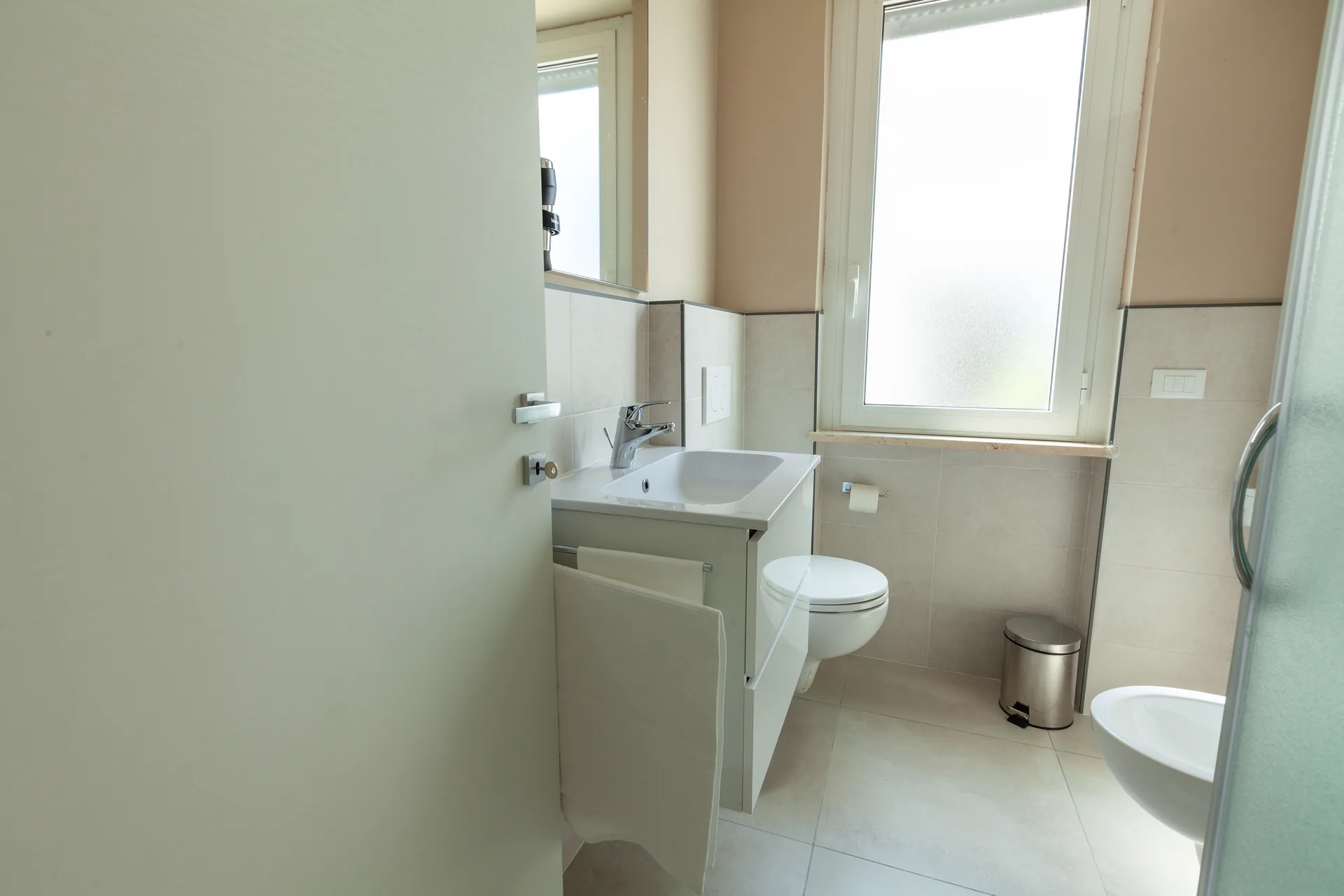 Bagno moderno con lavabo, WC sospeso, bidet e finestra