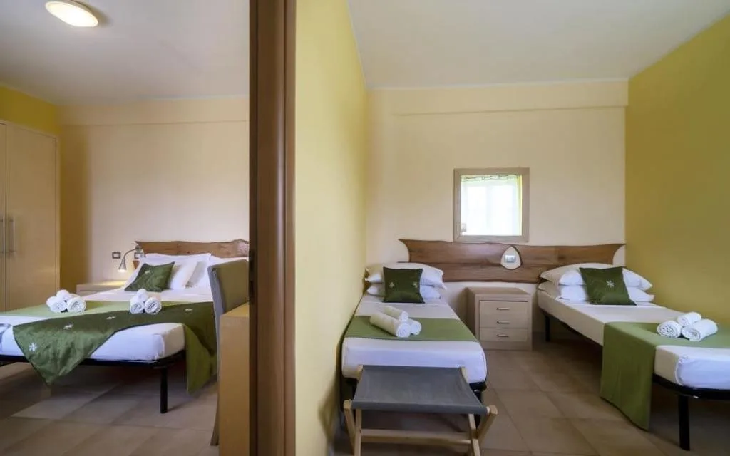 Camera familiare comunicante con letto matrimoniale e due letti singoli, pareti gialle