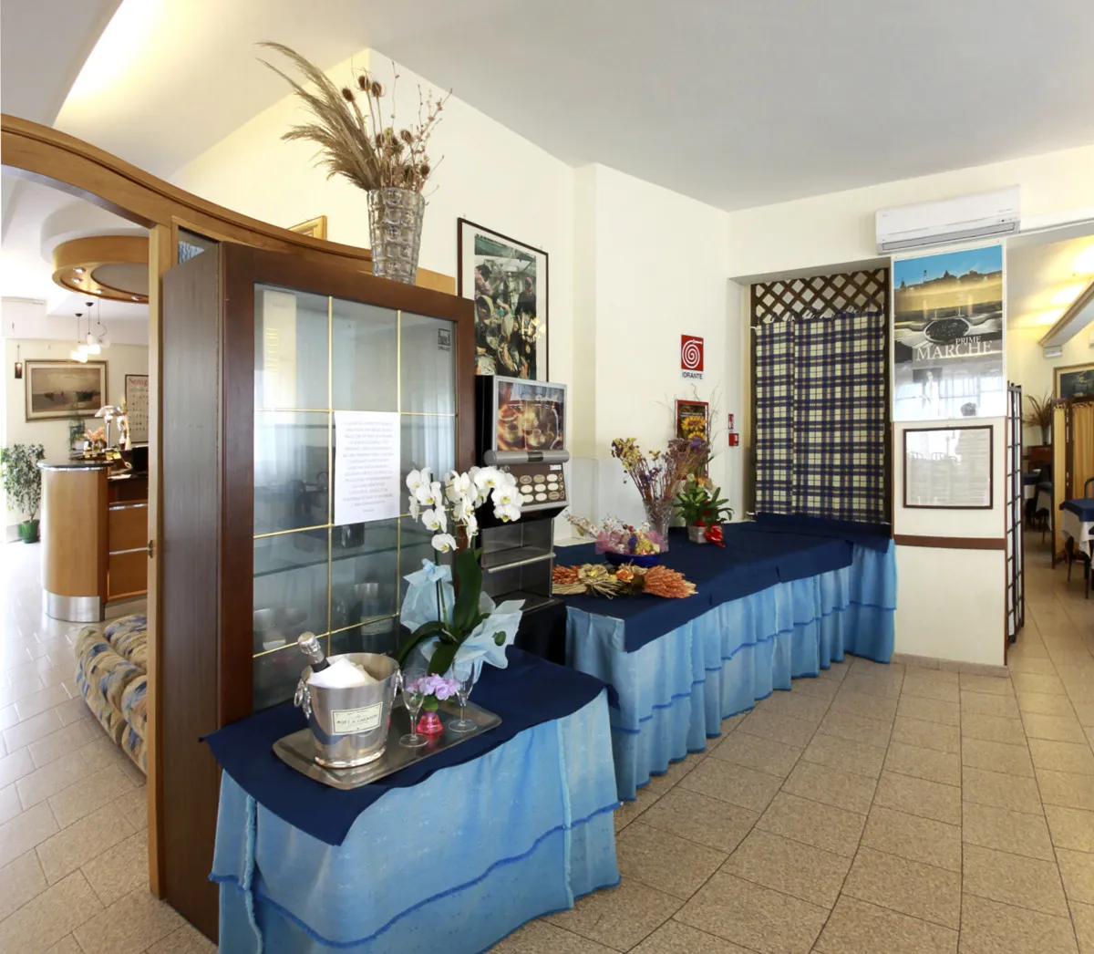 Ingresso dell'hotel con tavolo buffet decorato con fiori e reception