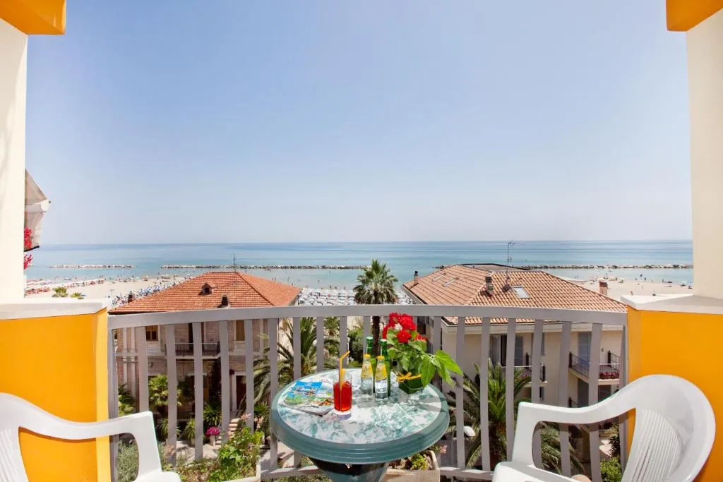 Balcone con tavolino, aperitivo e vista sul mare e sui tetti del paese