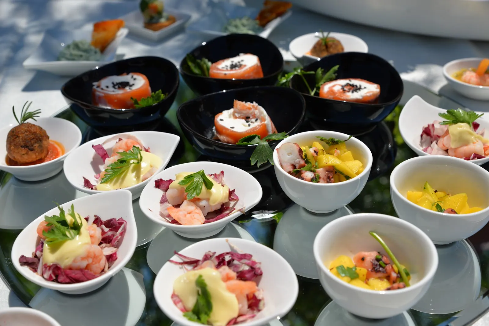 Antipasti gourmet di mare con gamberi, salmone e polpo serviti in ciotoline