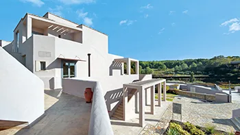 Esterno bianco dell'hotel con terrazza e vista sulla campagna