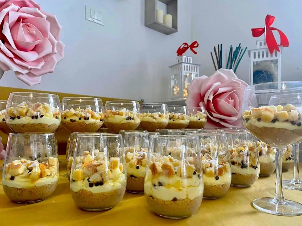 Dolci al cucchiaio serviti in bicchieri con decorazioni floreali