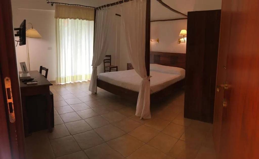 Camera matrimoniale con letto a baldacchino, scrivania e TV