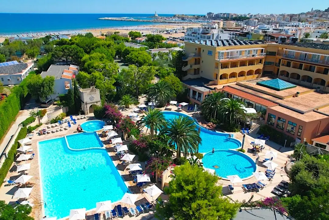 Vista aerea dell'hotel con piscine, palme e spiaggia sul mare sullo sfondo