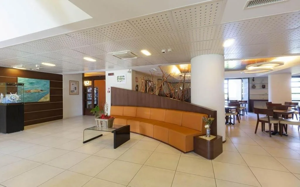 Hall dell'hotel con divano arancione curvo e reception