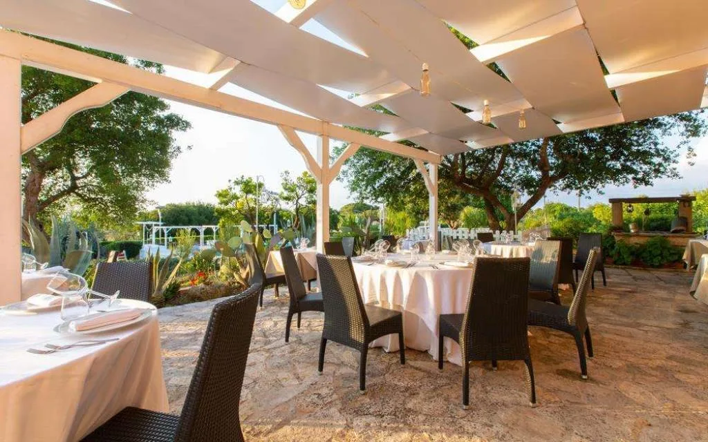 Terrazza ristorante esterna con tavoli eleganti e vista sul giardino