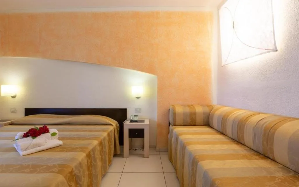 Camera con letto matrimoniale, divano e parete decorata in arancione