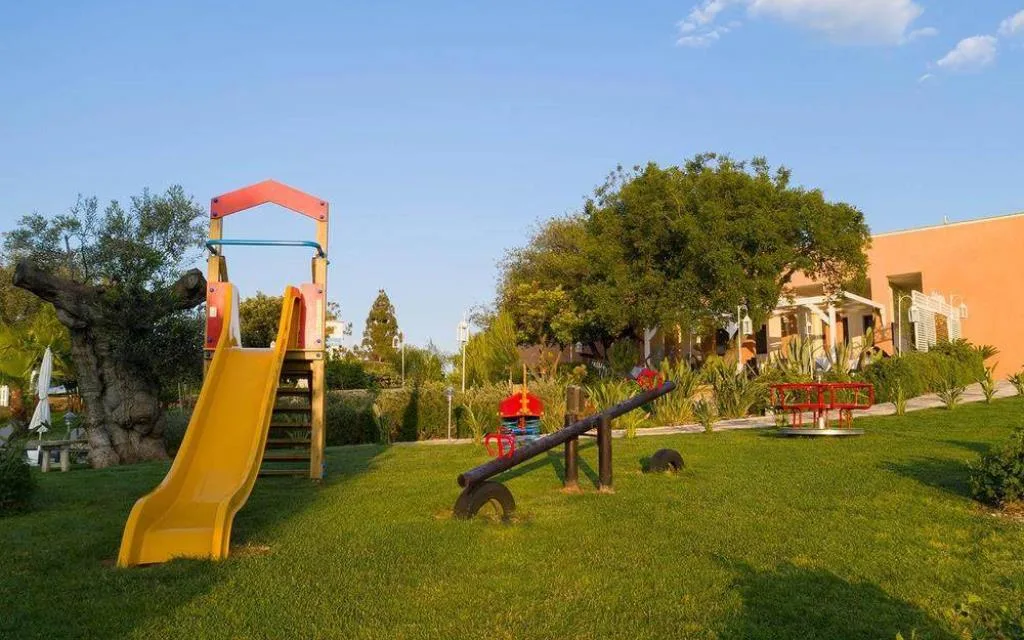 Area giochi per bambini con scivolo giallo e altalena nel giardino