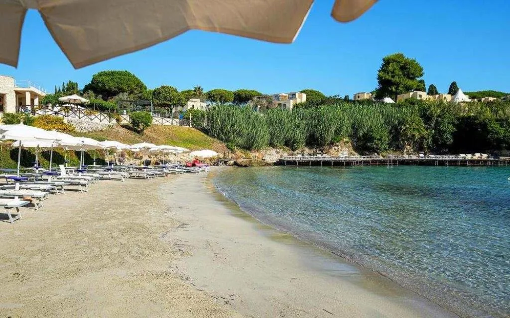 Spiaggia sabbiosa con ombrelloni e lettini sul mare cristallino