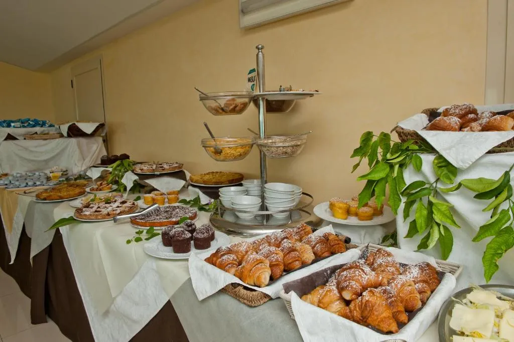 Buffet della colazione con cornetti, crostate, muffin e cereali