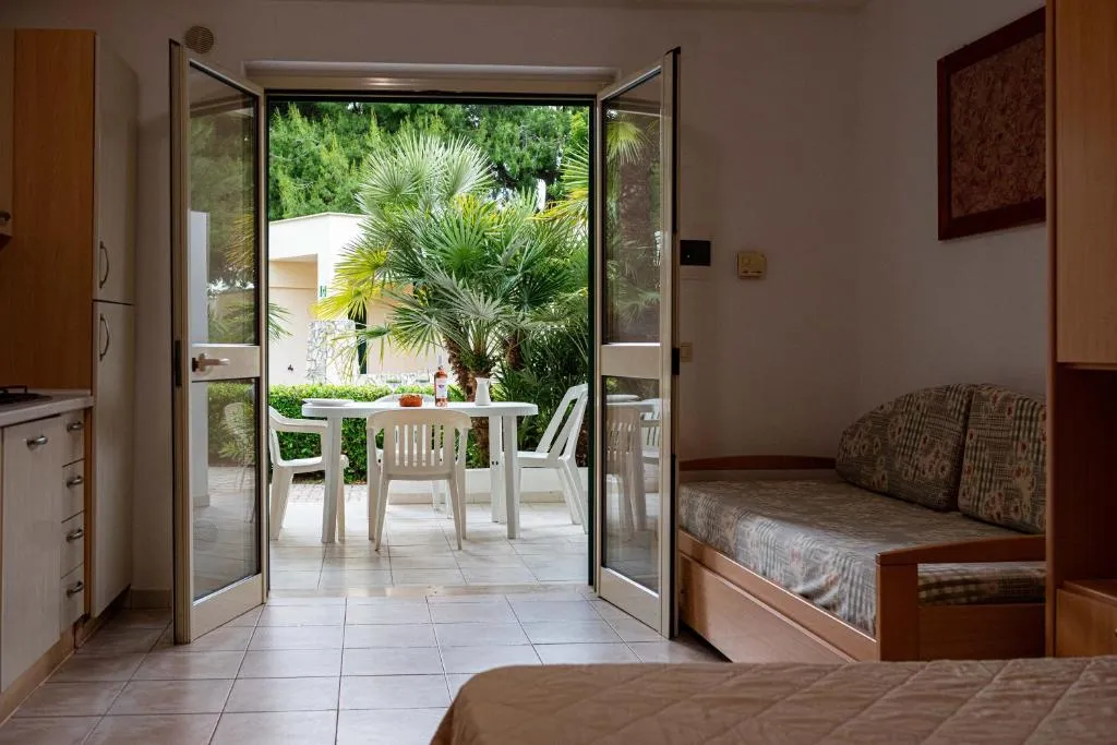 Interno di appartamento con vista sulla veranda e giardino tramite porta finestra