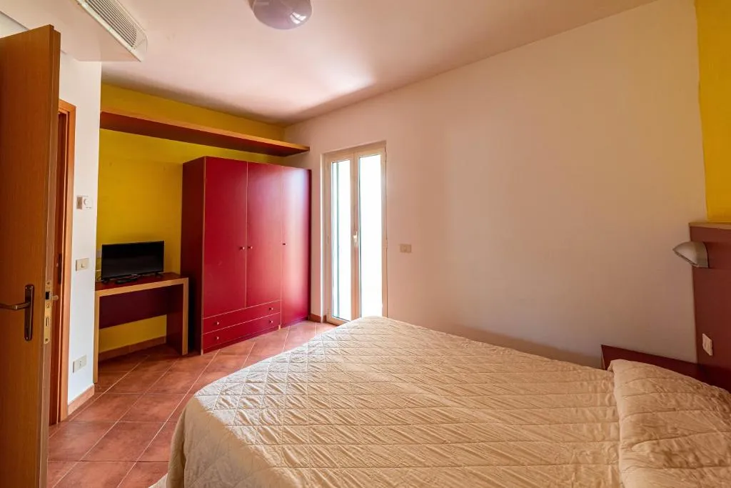 Camera da letto matrimoniale con armadio rosso e pareti gialle