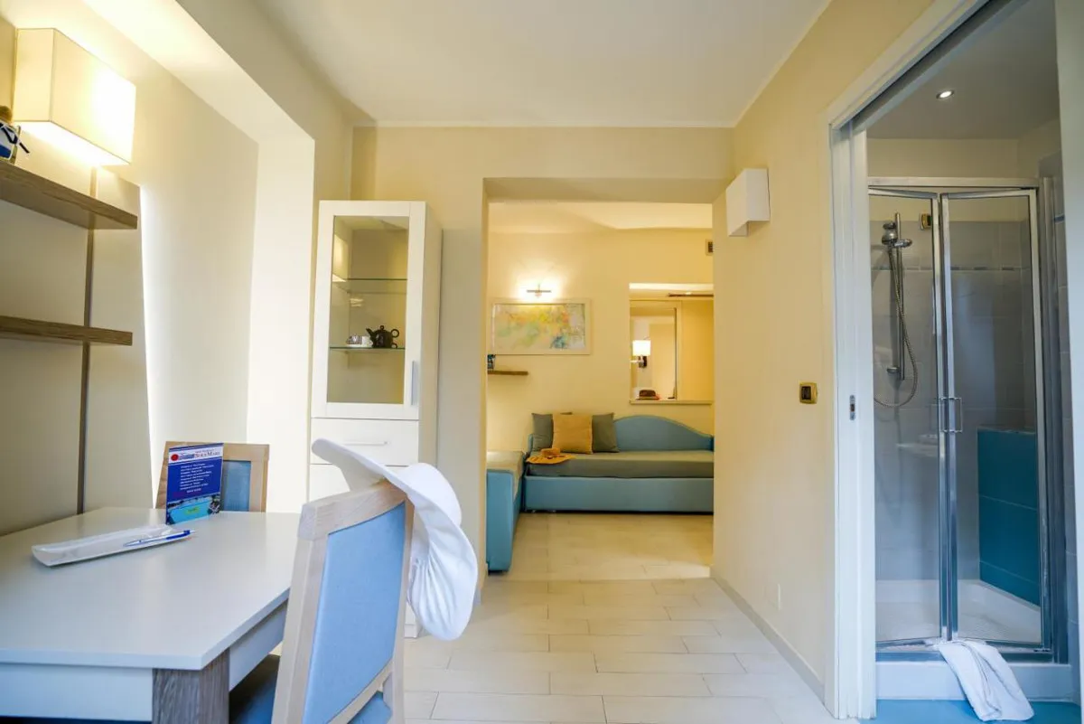 Interno di appartamento con divano, scrivania e bagno con doccia