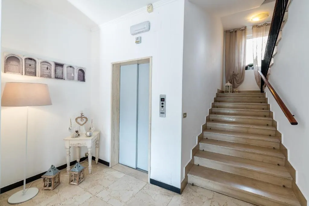 Ingresso con ascensore, scala e arredi shabby chic