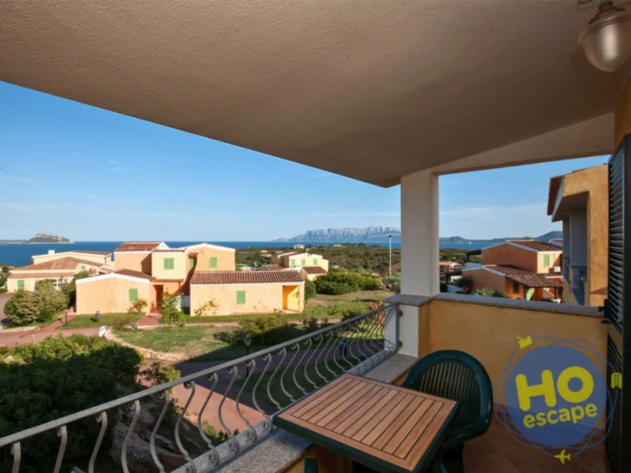 Terrazza con tavolino e vista sul mare e sul residence immerso nel verde