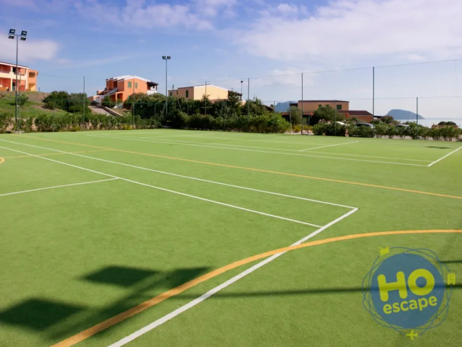 Campo sportivo in erba sintetica con vista sul mare e sulle case del residence