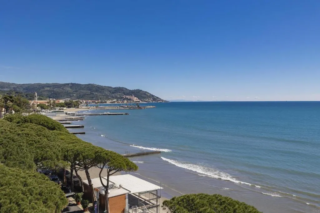 Vista panoramica della costa con spiaggia, pini marittimi e mare azzurro
