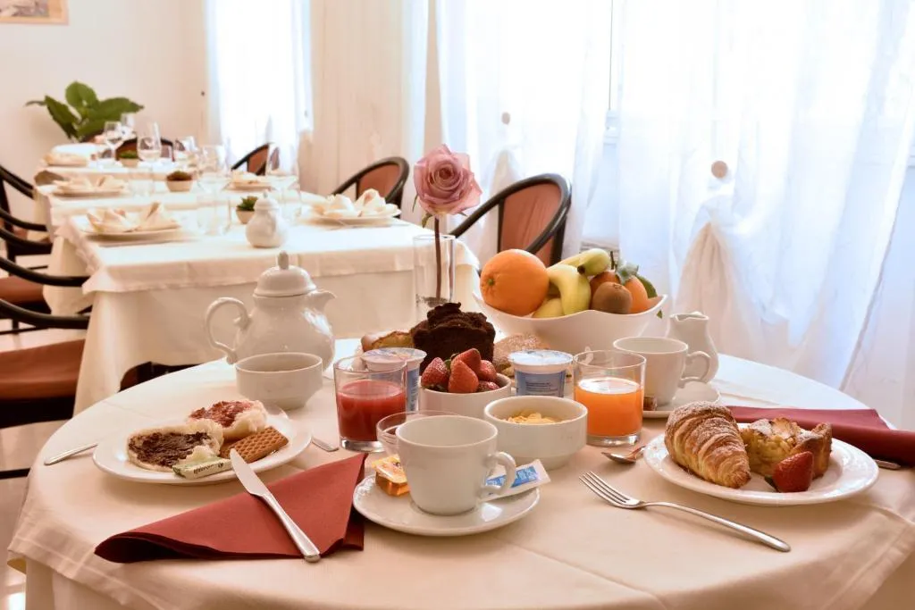 Tavolo della colazione con cornetti, frutta, succhi e dolci