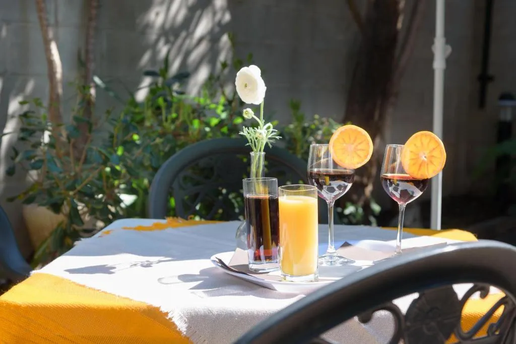 Tavolo all'aperto in giardino con succhi e calici decorati con arance