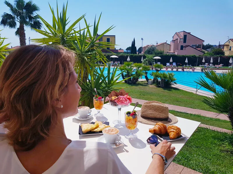Colazione all'aperto con cappuccini e cornetti vista piscina