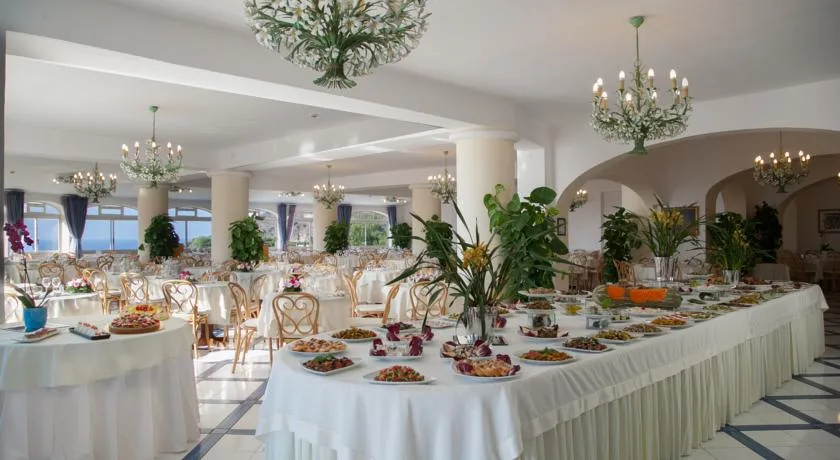 Sala ristorante con buffet ricco, lampadari e tavoli apparecchiati