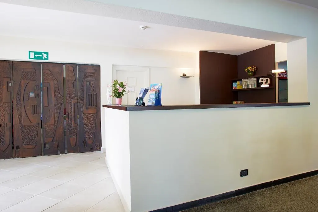 Reception dell'hotel con bancone e porta decorata in legno