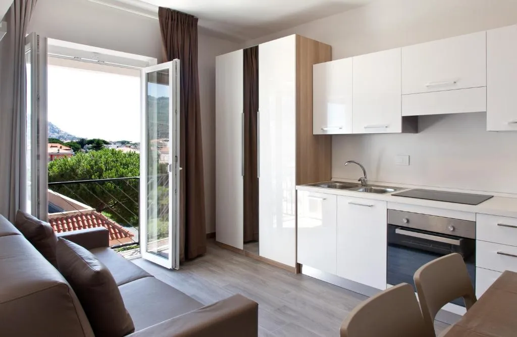 Appartamento con angolo cottura bianco, divano e balcone con vista