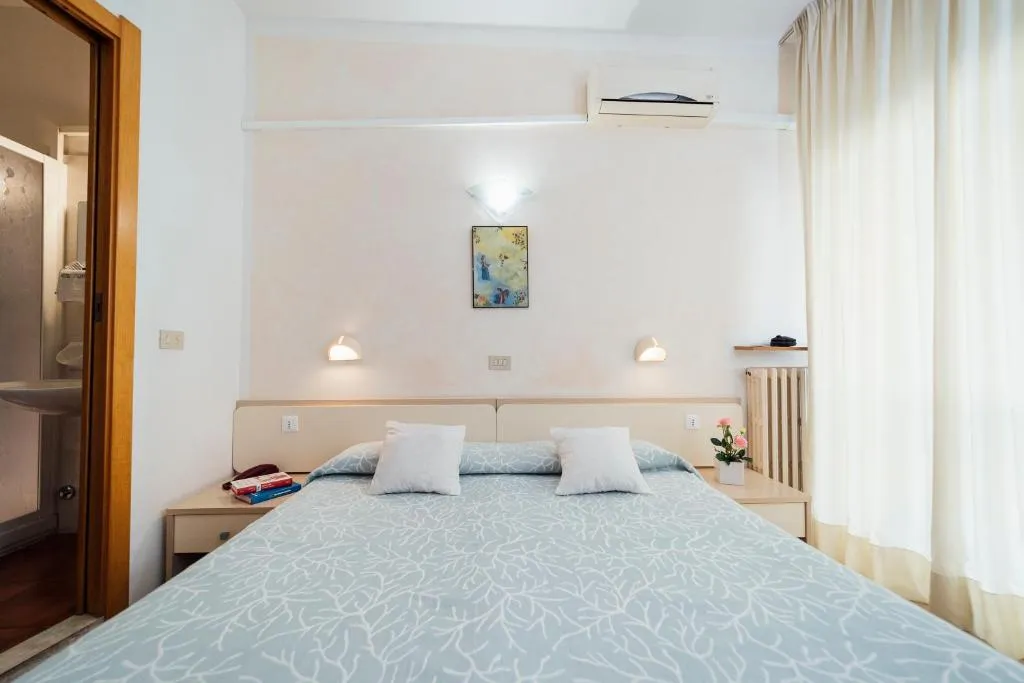 Camera matrimoniale con aria condizionata, quadro decorativo e accesso al bagno