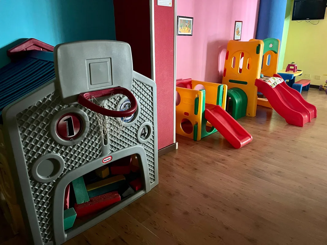 Area giochi per bambini con scivoli colorati e canestro da basket