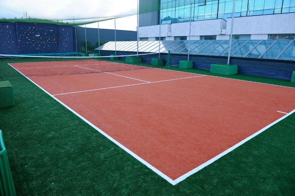 Campo da tennis in terra rossa accanto all'edificio dell'hotel