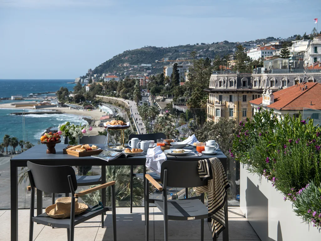 Terrazza con tavolo per la colazione e vista sul lungomare e la costa di Sanremo