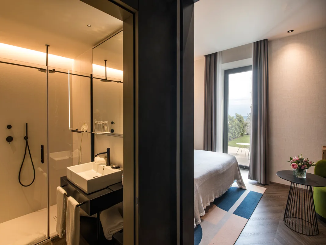 Bagno moderno con doccia in vetro affacciato sulla camera con vista