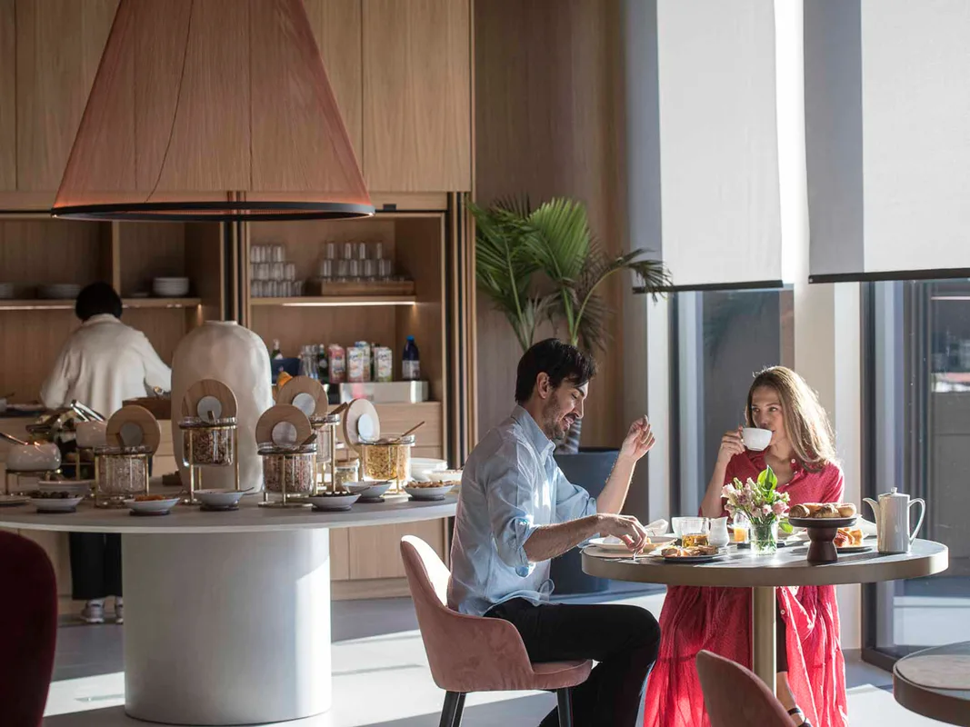 Coppia che fa colazione al buffet dell'hotel in una sala luminosa e moderna