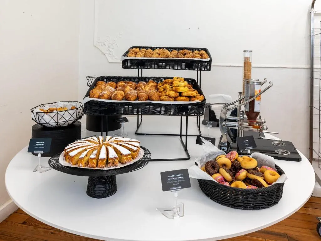 Buffet della colazione con cornetti, dolci e ciambelle su tavolo bianco