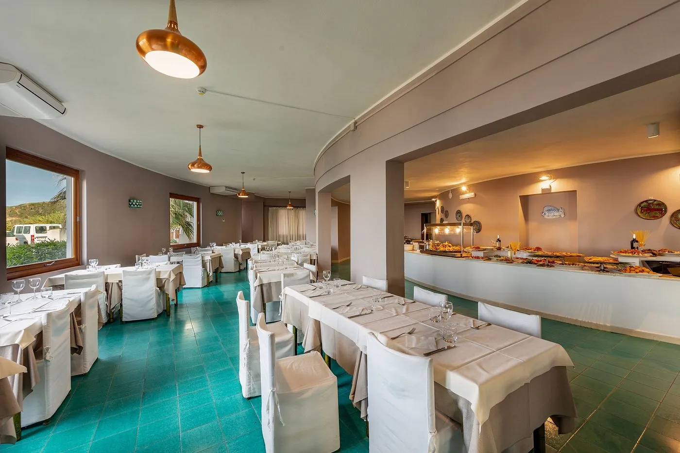 Sala ristorante interna con tavoli apparecchiati e buffet illuminato